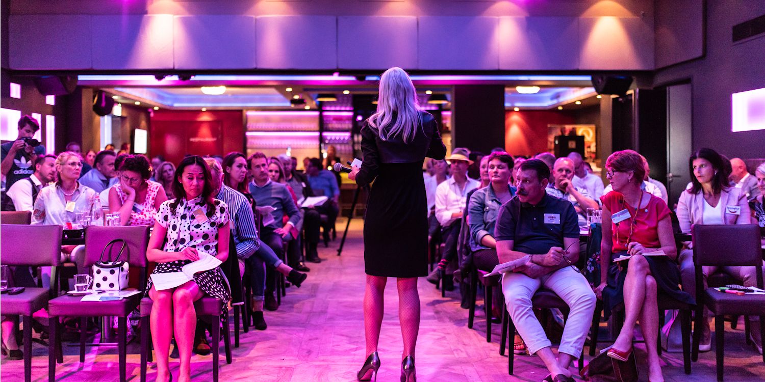 Chantal van den Berg als keynote spreker op het podium voor een volle zaal tijdens een masterclass